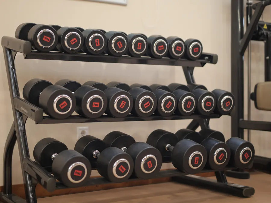 Zona de peso libre con mancuernas ordenadas en el rack