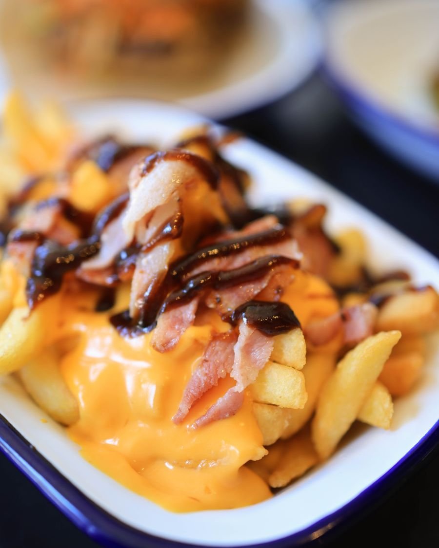 Papas fritas con cheddar derretido y panceta
