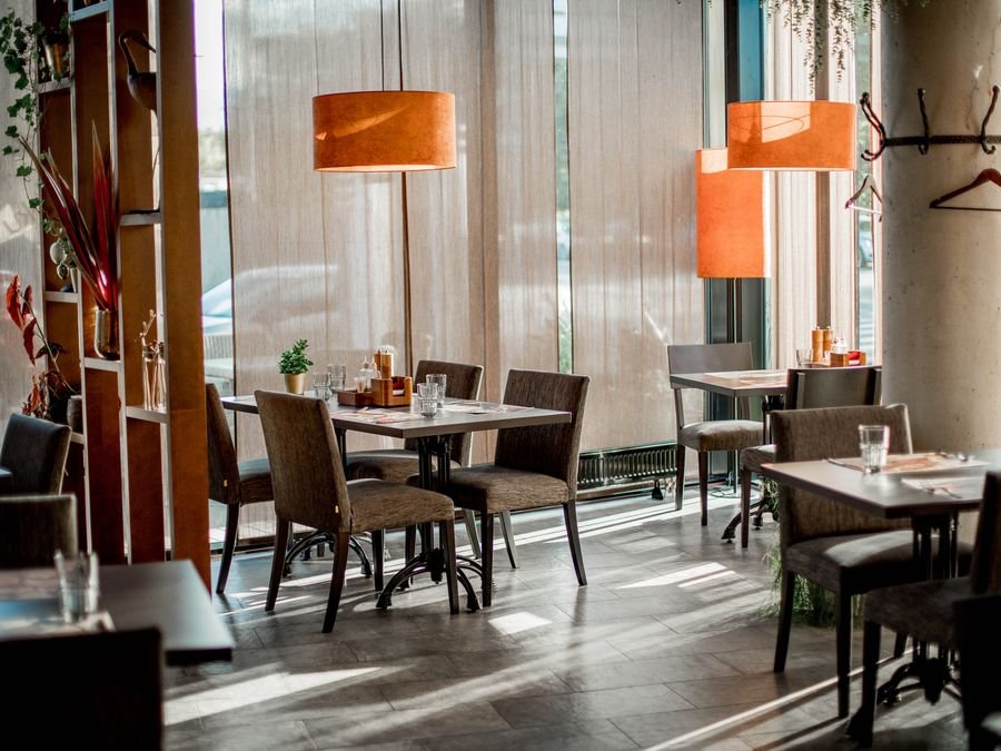 Salón del restaurante con luz cálida y mesas preparadas