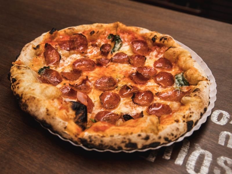 Pizza calabresa con rodajas de salamín y muzzarella