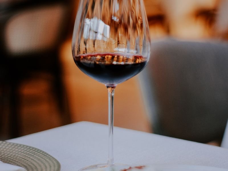 Copa de vino tinto servida en la mesa del restaurante